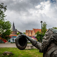 Statue zeigt auf Holstentor (c) woods of voices